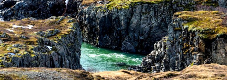 cliffs with grass and a river