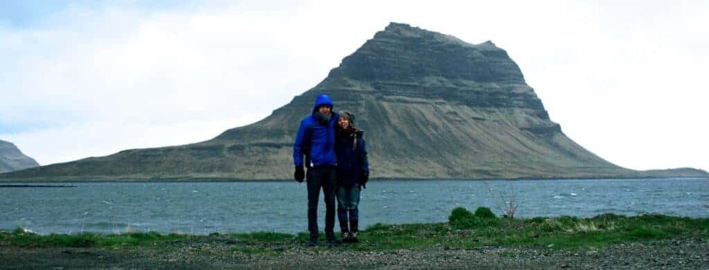 couple standing in front of a lake and mountain