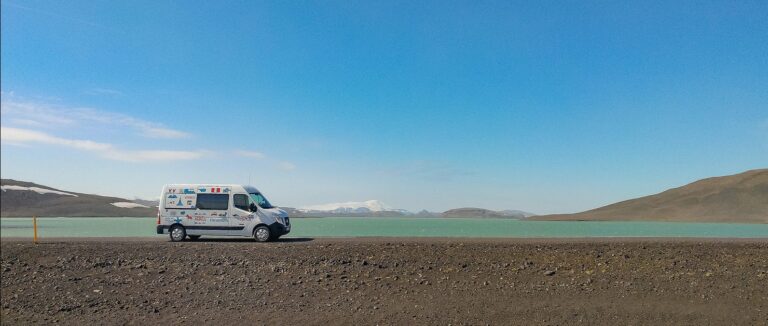 renault master campervan on gravel road next to lake