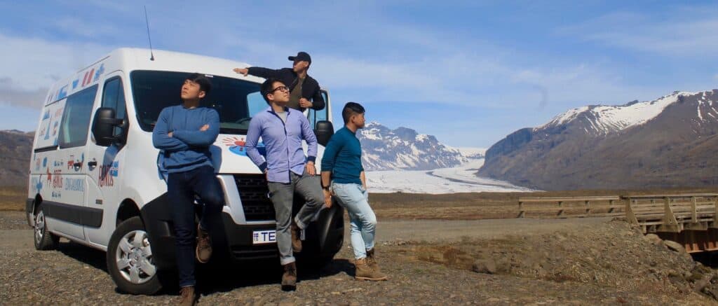 4 man sitting and standing around rent.is campervan