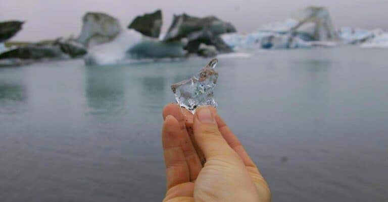 Hand holding a piece of glacier from the glacier lagoon Jökulsárlón