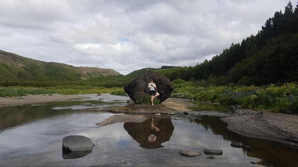Man standing in a yoga pose in the nature of Iceland