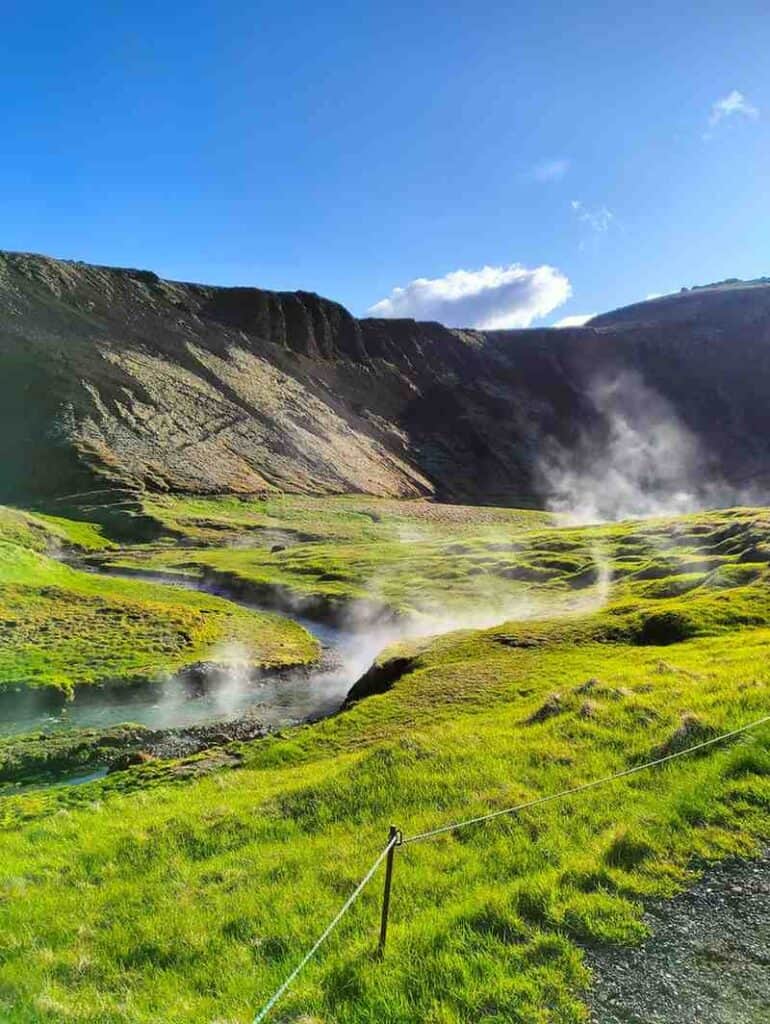 A hot spring lake in a grassy field.