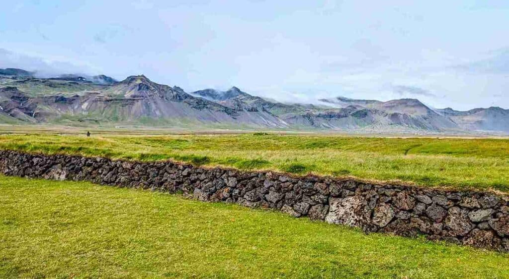A large grassy field and rock barrier