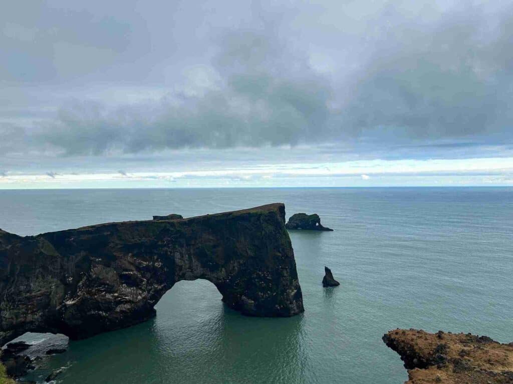"An SUV Adventure" A strangely shaped rock located in the ocean