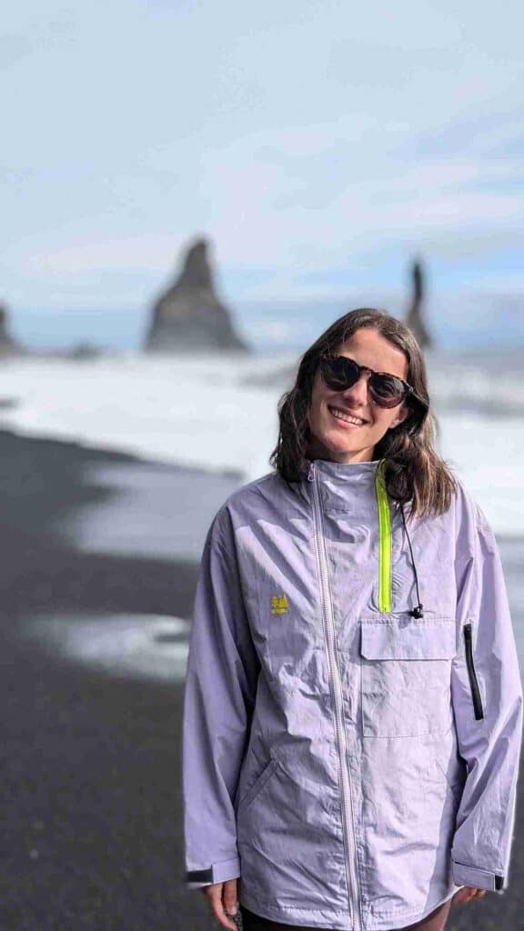 A woman standing on a black beach