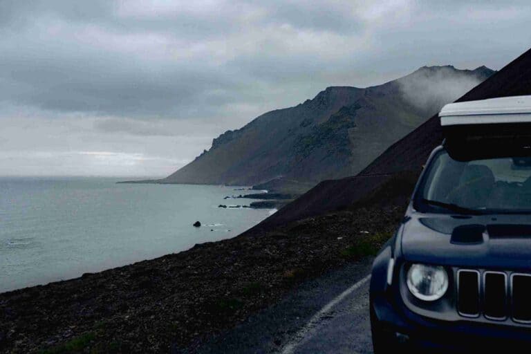 Jeep Renegade with a closed rooftent, posed by the coast of Iceland.