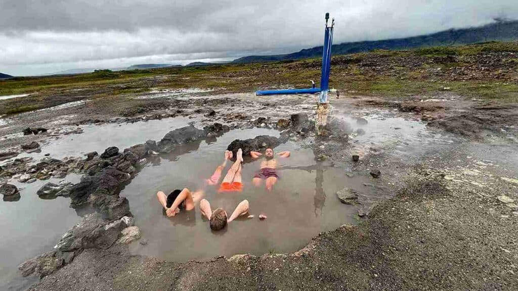 Three guys laying in a shallow puddle