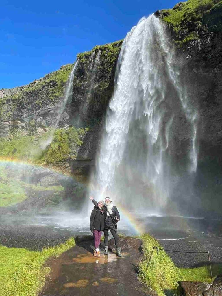 Two girls standing by a waterfall located in the golden circle.