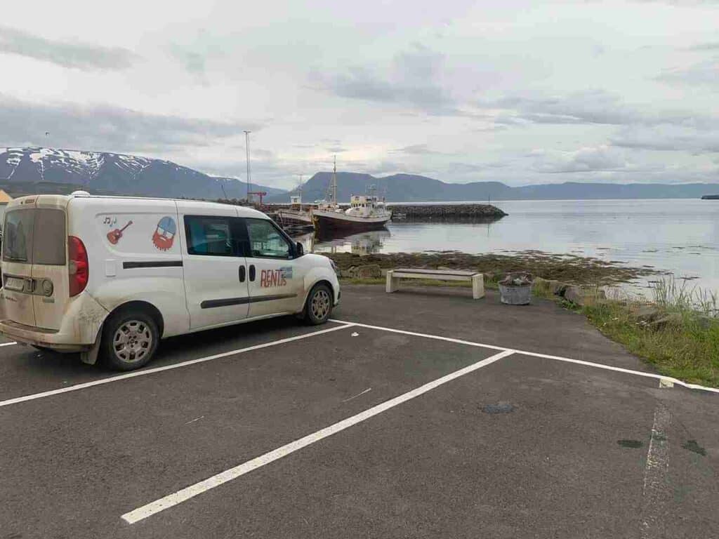 A fiat doblo parked in a parking spot by the harbour