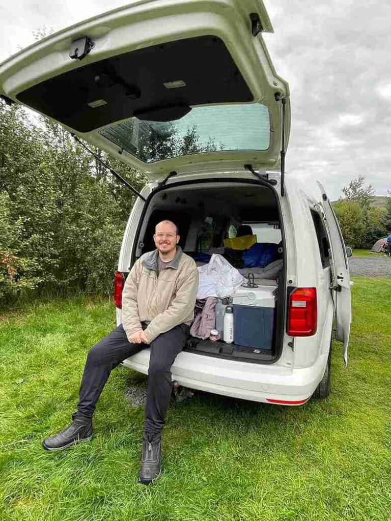 A man sitting in a trunk of the caddy.